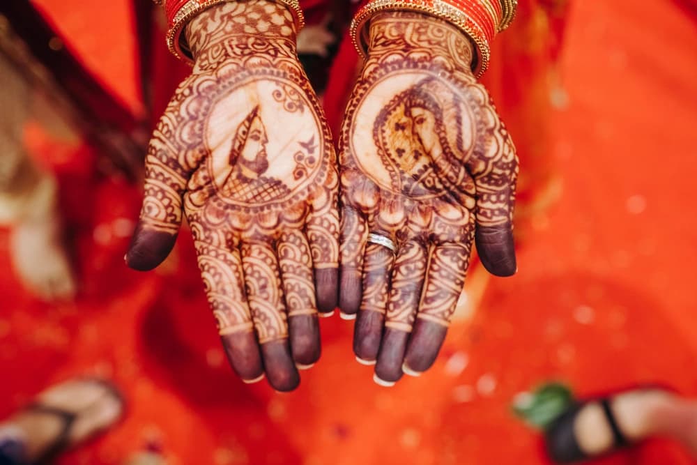 Intricate portrait henna design on bride's hands